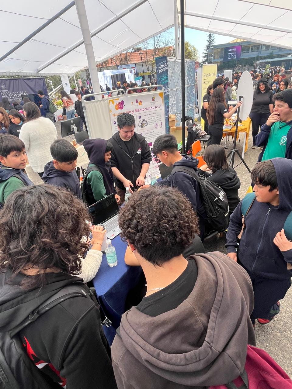 Escolares rodeando uno de los stands del Departamento de Neurociencia en NeuroFest 2026